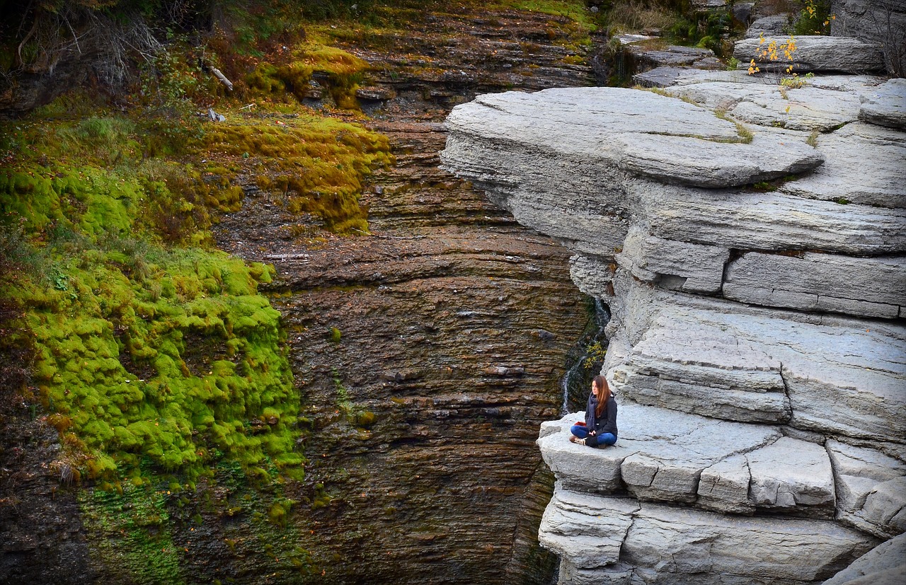Une femme qui médite sur un rocher